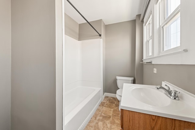 full bathroom featuring toilet, baseboards, stone finish flooring, vanity, and shower / bathing tub combination