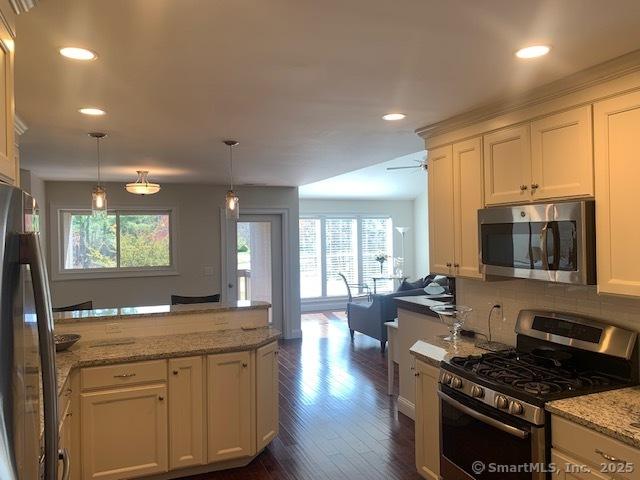 kitchen with recessed lighting, open floor plan, white cabinetry, and stainless steel appliances
