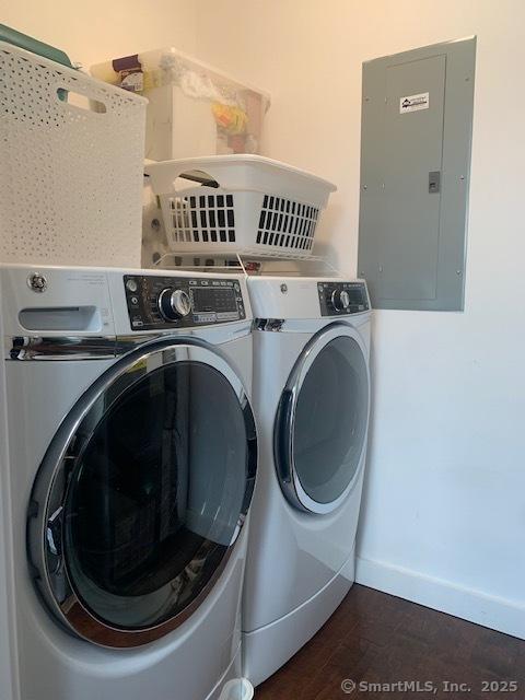 laundry area with independent washer and dryer, electric panel, baseboards, dark wood-style flooring, and laundry area
