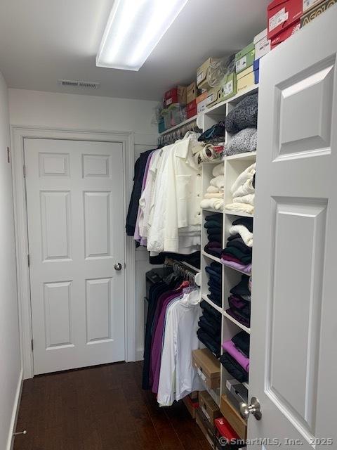 walk in closet featuring visible vents and dark wood-style floors