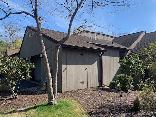view of side of home featuring roof with shingles