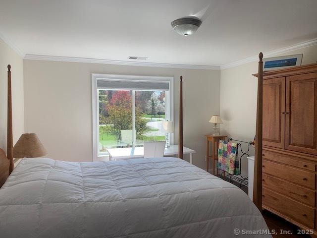 bedroom with crown molding and visible vents