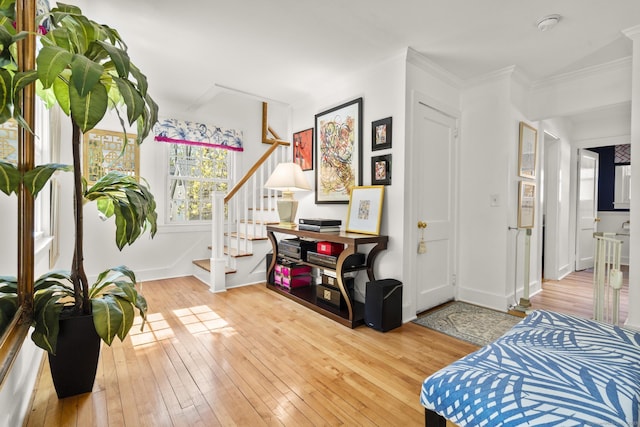 sitting room featuring baseboards, ornamental molding, stairs, and hardwood / wood-style flooring
