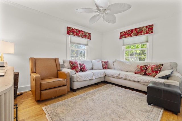 living room with plenty of natural light, ornamental molding, and light wood-type flooring