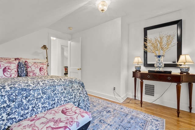 bedroom with visible vents, baseboards, and wood finished floors