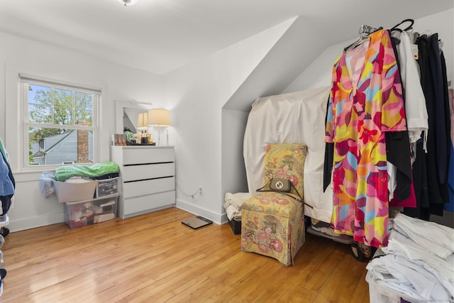 bedroom featuring baseboards, vaulted ceiling, and hardwood / wood-style flooring