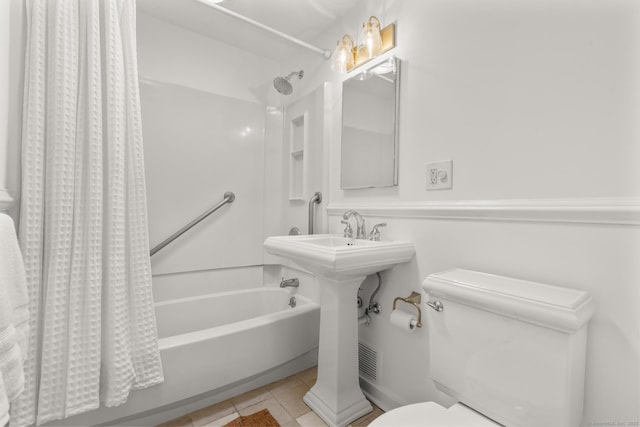 full bathroom with tile patterned flooring, shower / tub combo with curtain, and toilet