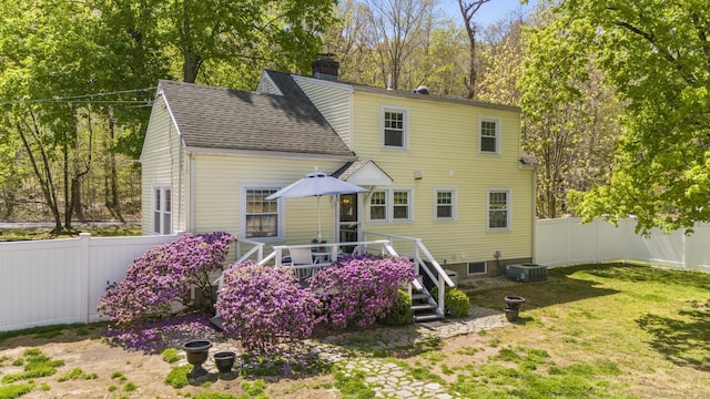 rear view of house with a fenced backyard, a chimney, central AC, and roof with shingles