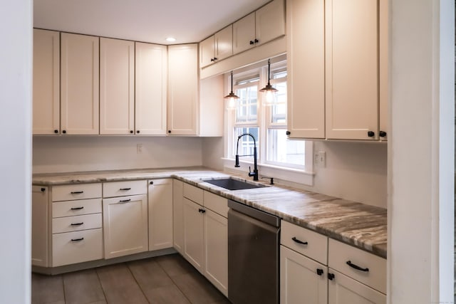 kitchen featuring dishwasher, a sink, white cabinetry, light tile patterned flooring, and light stone countertops