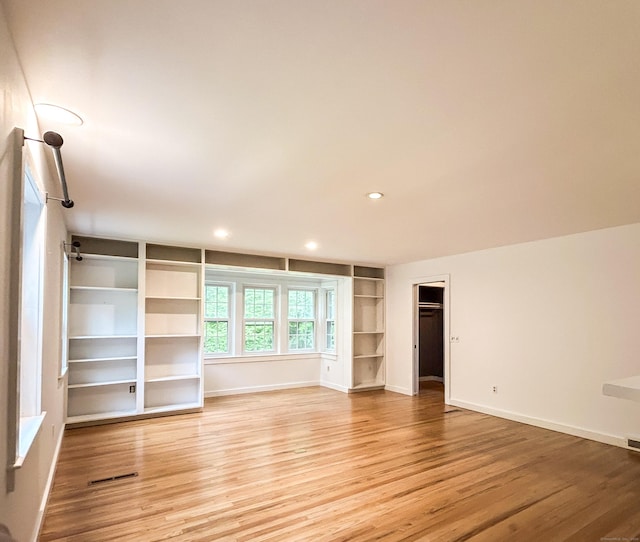 unfurnished room featuring light wood-type flooring, baseboards, recessed lighting, and built in features