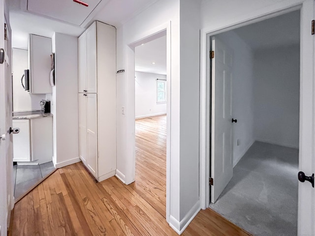 hallway with light wood finished floors and baseboards