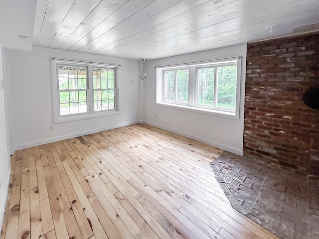 spare room with wood-type flooring, baseboards, and wooden ceiling