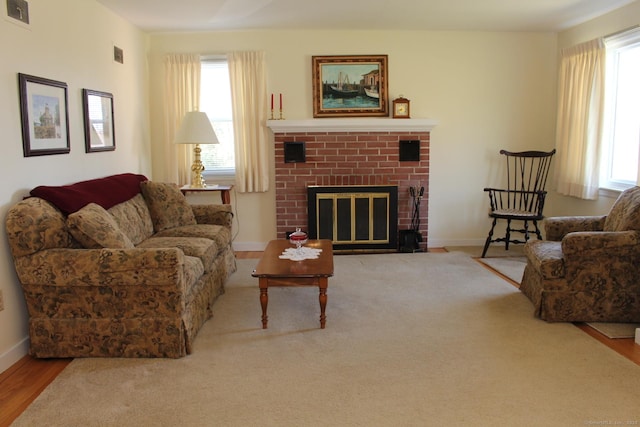 living room with a fireplace, visible vents, and baseboards
