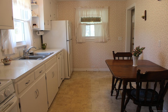 kitchen with open shelves, white cabinets, a sink, baseboards, and stove