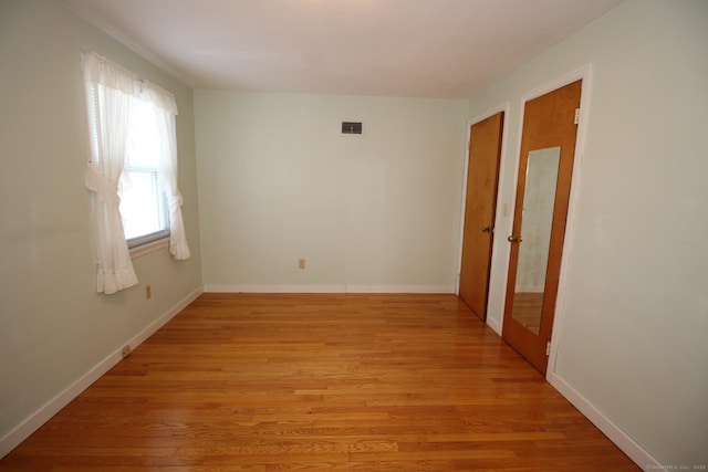 unfurnished room with visible vents, baseboards, and light wood-style floors