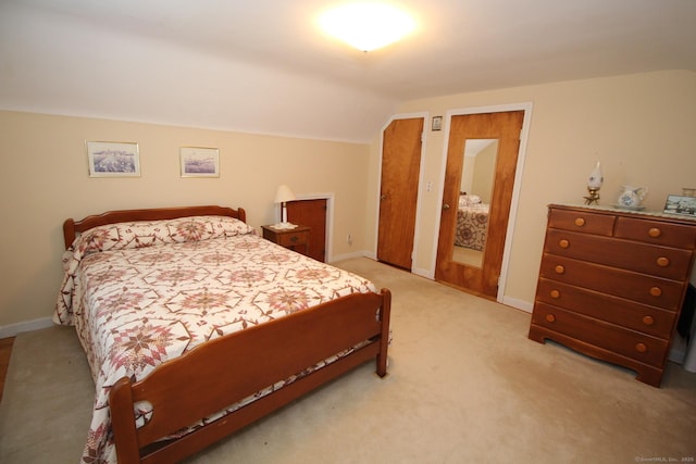 bedroom with lofted ceiling, carpet, and baseboards