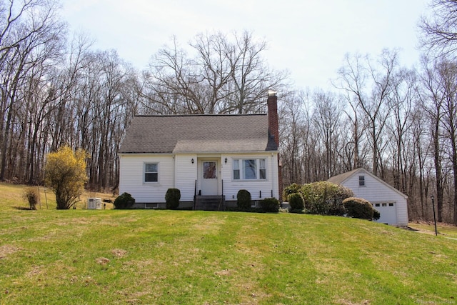 new england style home with a chimney, a garage, a front lawn, and an outbuilding