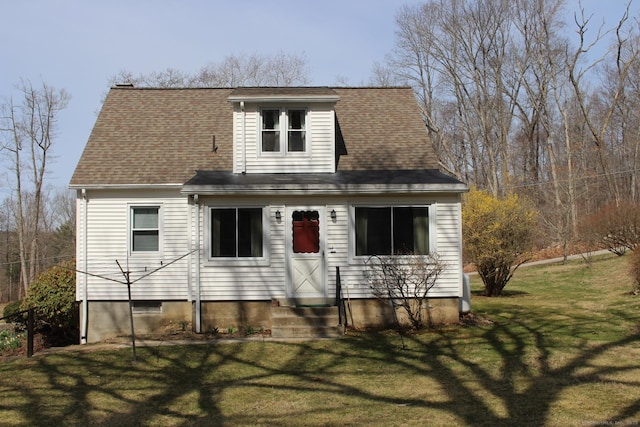 view of front of home with a front yard, entry steps, and roof with shingles