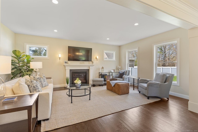 living room with a glass covered fireplace, baseboards, recessed lighting, and wood finished floors