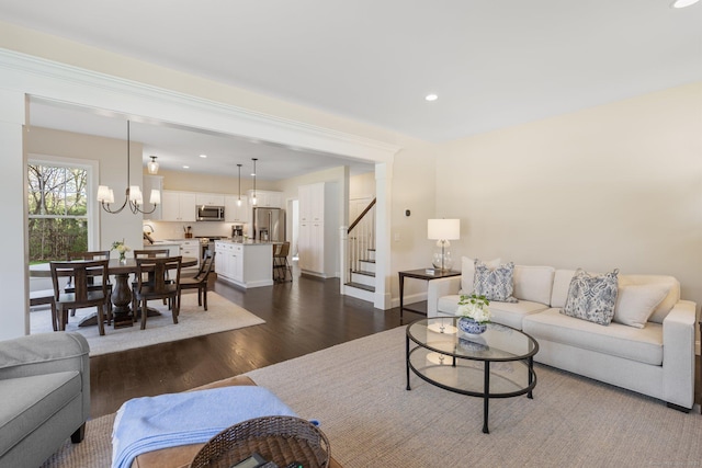 living room with recessed lighting, a notable chandelier, stairway, and dark wood-type flooring
