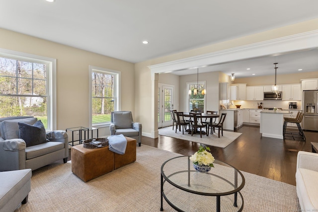 living area featuring dark wood-style flooring, baseboards, recessed lighting, and an inviting chandelier