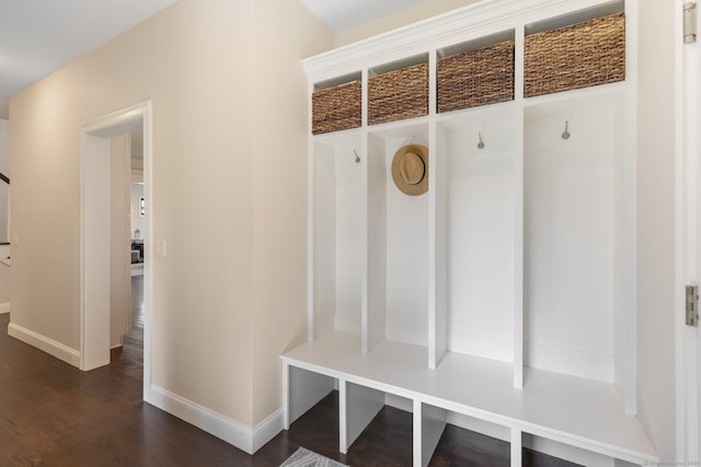 mudroom with baseboards and dark wood-type flooring