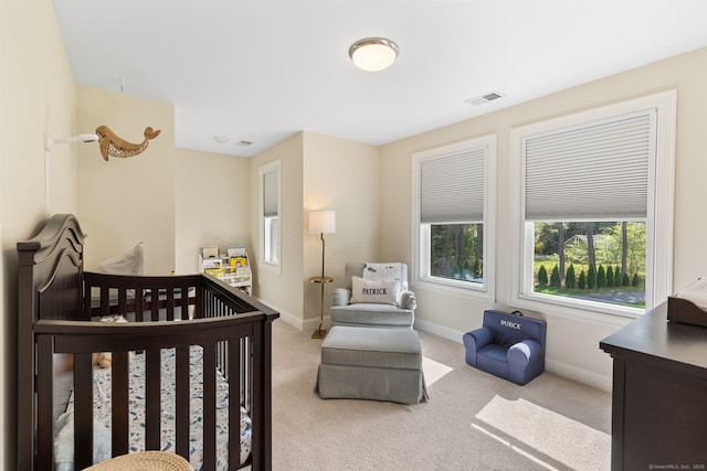 carpeted bedroom featuring a nursery area, baseboards, and visible vents