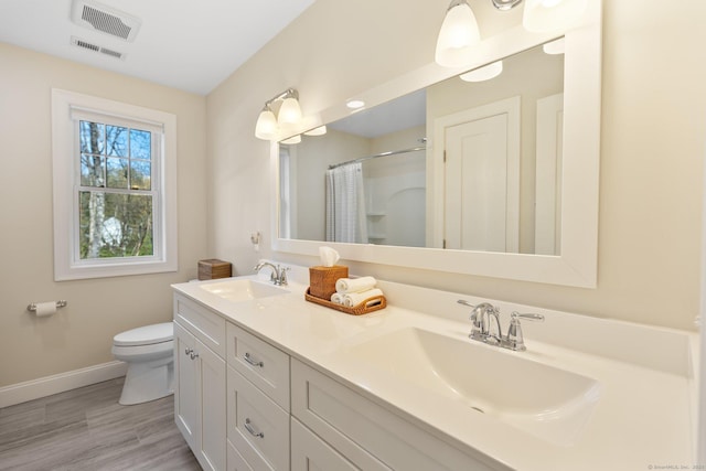 bathroom featuring baseboards, a sink, curtained shower, and toilet