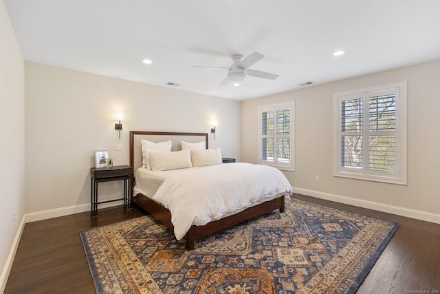 bedroom with visible vents, baseboards, dark wood-type flooring, and ceiling fan