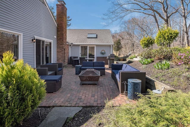 view of patio with an outdoor living space with a fire pit