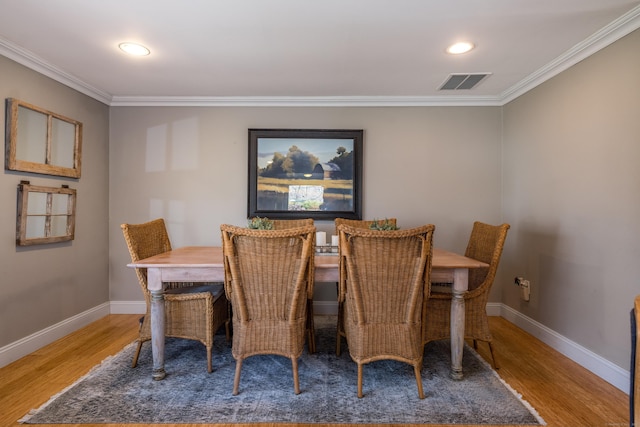 dining room featuring crown molding, visible vents, and wood finished floors