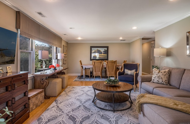 living room featuring recessed lighting, light wood-style floors, crown molding, visible vents, and baseboards