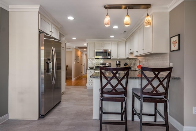 kitchen with stainless steel appliances, decorative backsplash, ornamental molding, and a peninsula