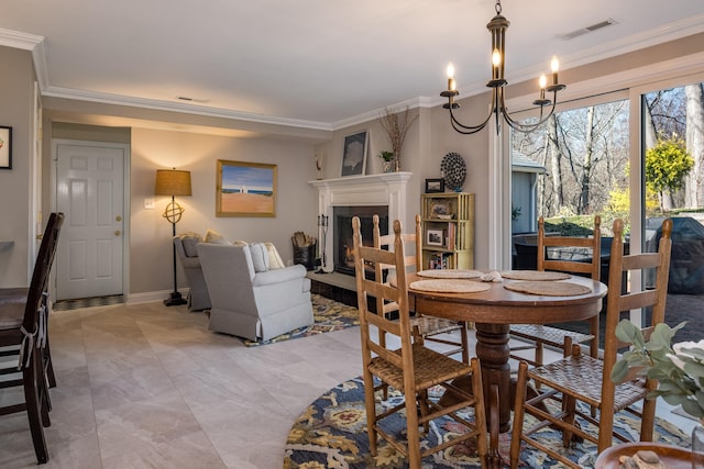 dining space with visible vents, an inviting chandelier, and crown molding