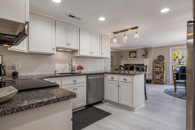 kitchen with tasteful backsplash, stainless steel dishwasher, a peninsula, and a sink