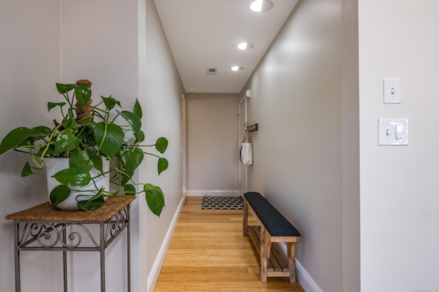hall featuring baseboards, recessed lighting, visible vents, and light wood finished floors