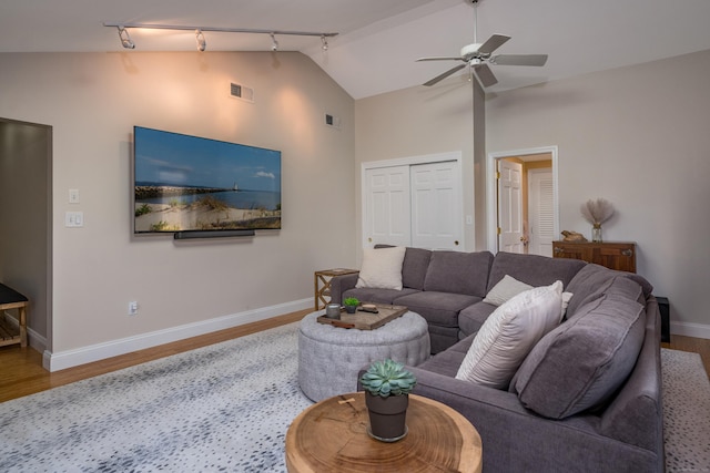 living room with a ceiling fan, track lighting, wood finished floors, and visible vents
