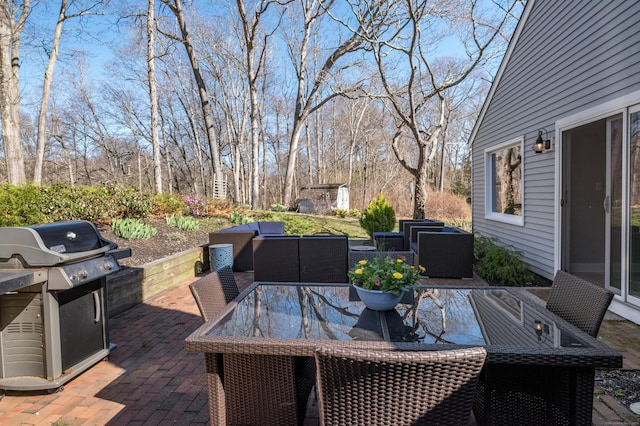 wooden terrace with a storage unit, area for grilling, outdoor dining area, and a patio area