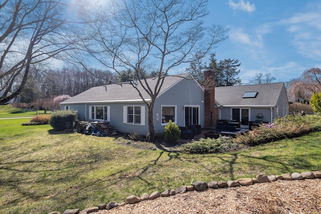rear view of property featuring a patio area, a yard, a chimney, roof with shingles, and an outdoor hangout area