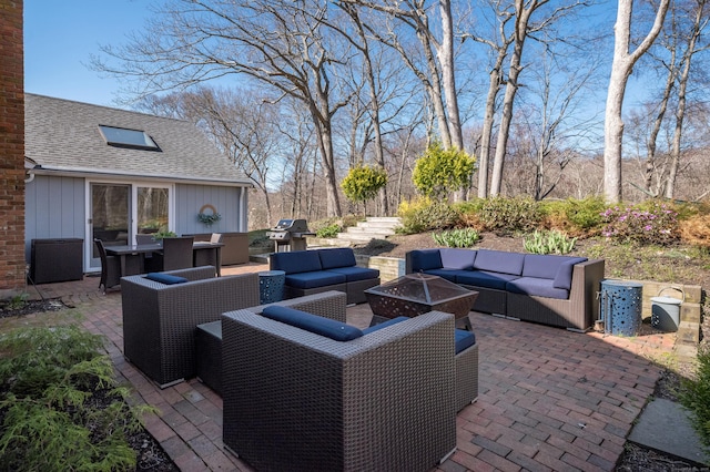 view of patio with area for grilling and an outdoor living space with a fire pit