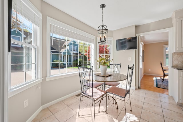 dining area featuring baseboards, light tile patterned floors, and a chandelier