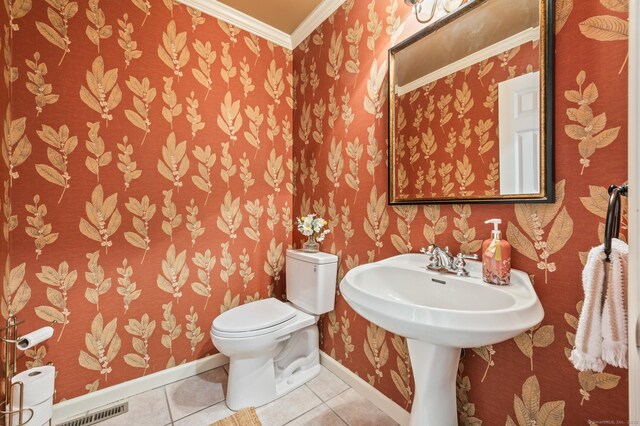half bath with wallpapered walls, crown molding, baseboards, tile patterned flooring, and toilet
