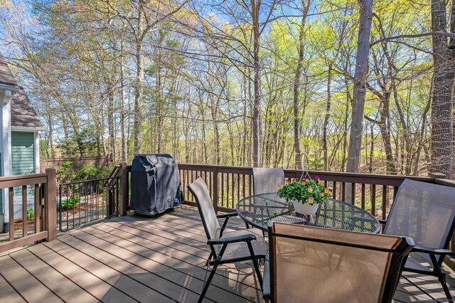 deck featuring outdoor dining area and a grill