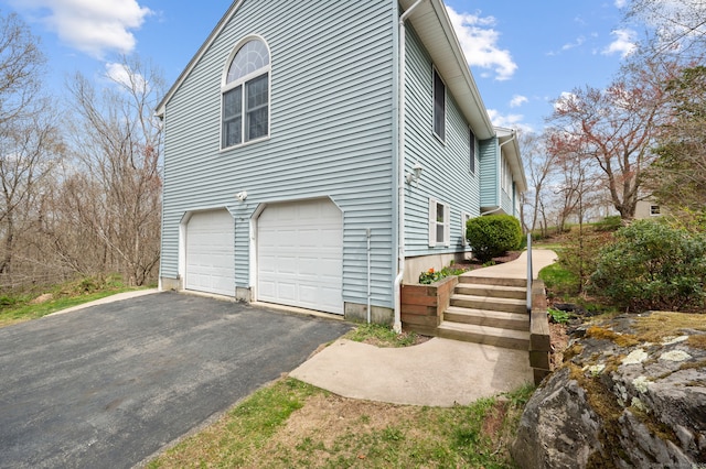 view of side of property featuring an attached garage and driveway