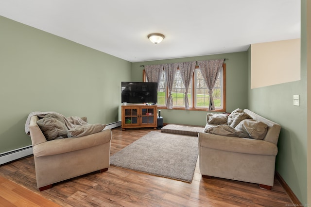 living area with baseboards, wood finished floors, and a baseboard radiator