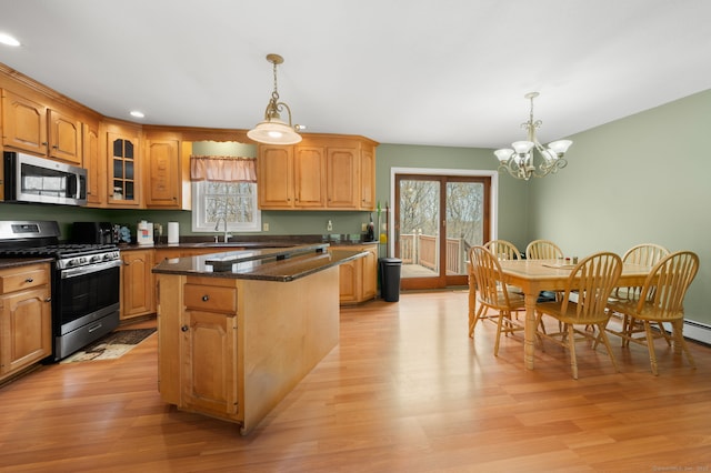 kitchen featuring stainless steel appliances, a notable chandelier, plenty of natural light, and light wood-style floors