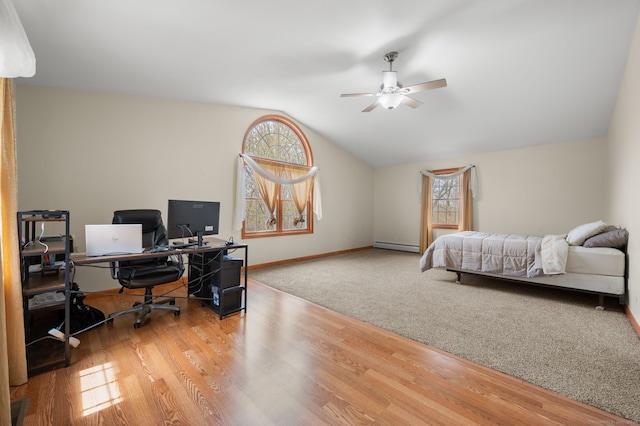 bedroom featuring baseboards, baseboard heating, wood finished floors, and lofted ceiling