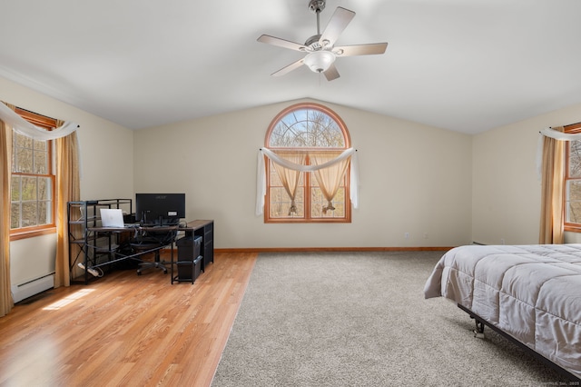 bedroom featuring baseboard heating, a ceiling fan, baseboards, wood finished floors, and vaulted ceiling