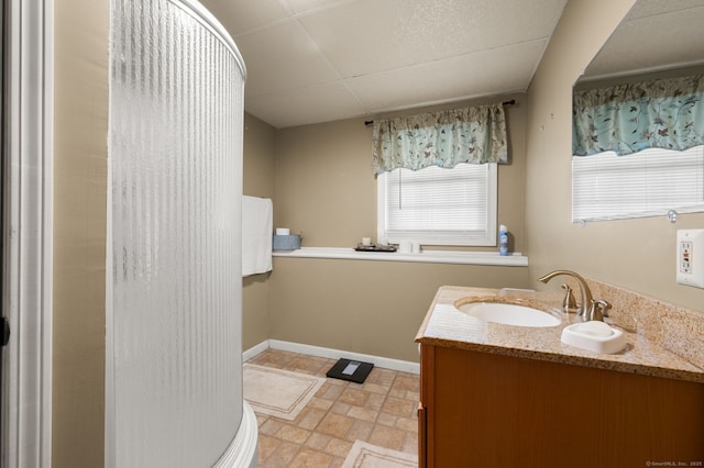 bathroom featuring baseboards, stone finish floor, and vanity