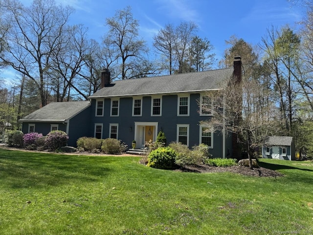 colonial-style house with a front lawn and a chimney